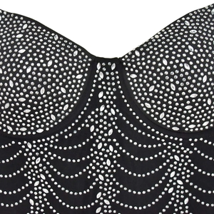 Detail of silver rhinestones in wavy patterns on black mesh dress fabric