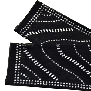 Detail of black mesh sleeves featuring decorative rhinestones in geometric patterns