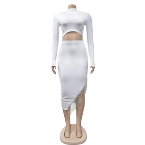 Détail de robe blanche en maille côtelée avec taille ajourée et franges de perles argent