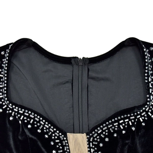Détail du col de robe en velours avec strass brillants et empiècement en résille