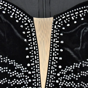 Détail d'une robe en velours noir avec décolleté en V, tulle invisible et strass