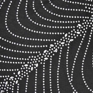 Detail of sparkling silver rhinestones in a radial pattern on black mesh fabric
