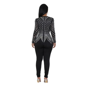 Rear view of black long sleeve jumpsuit featuring intricate silver rhinestone patterns on the back