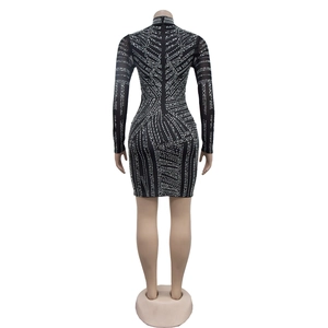 Détail de strass argentés brillants sur une robe bodycon noire à manches longues en mesh
