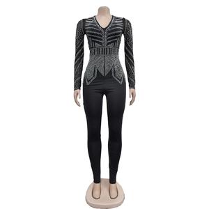 Detailed close-up of a black long-sleeve bodysuit with symmetric silver rhinestone patterns