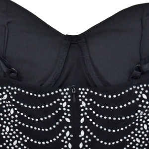Close-up of V-neckline with adjustable straps and wave-patterned rhinestones on black dress