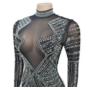 Détail de robe en maille noire transparente avec strass argentés et découpe frontale
