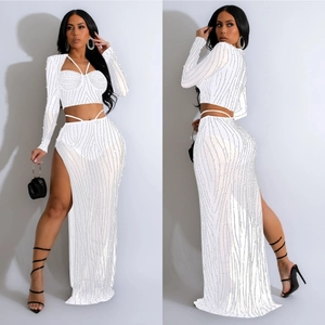 Ensemble blanc deux pièces chic avec sequins, haut court manches longues et jupe fendue