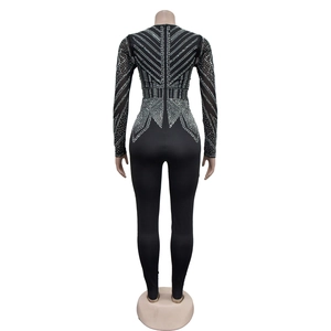 Detailed back view of black V-neck jumpsuit featuring intricate silver rhinestone patterns