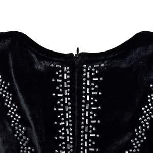 Détail d'une robe en velours noir avec strass argentés et fermeture éclair invisible