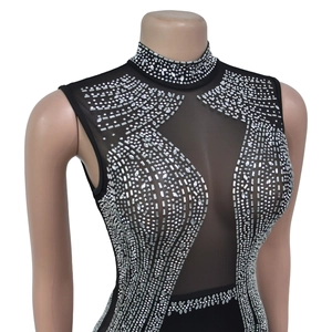 Detailed close-up of mesh splicing and sparkling rhinestone patterns on a black dress