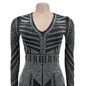Close-up of V-neck jumpsuit featuring geometric silver rhinestones and mesh sleeves