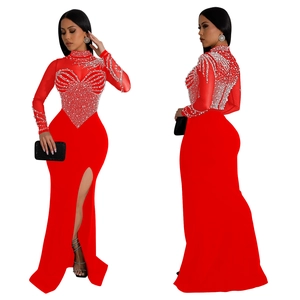 Detail of red mesh evening gown featuring intricate white pearls and side slit