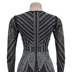 Detail of black mesh jumpsuit featuring silver rhinestone patterns and back zipper closure