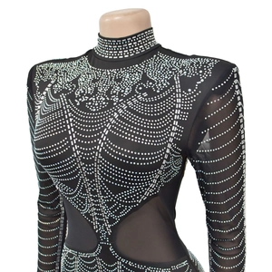 Detail of black mesh jumpsuit with high collar and intricate silver rhinestone patterns