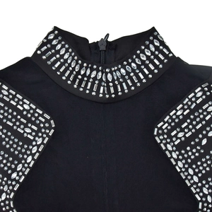 Détail de robe en maille à col montant, tissu noir avec strass et fermeture éclair au dos
