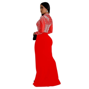 Detail of red long-sleeve evening gown with dense white sequin embroidery and fishtail hem