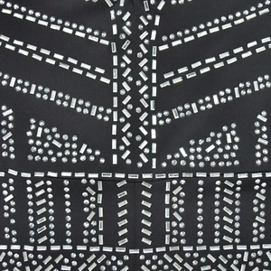 Close-up of geometric rhinestone patterns on a black V-neck long sleeve jumpsuit