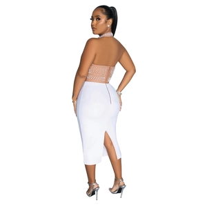 Dettaglio del top a lupetto in mesh con perle e gonna midi bianca con spacco posteriore