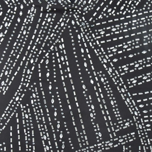 Détail du tissu en maille noire avec des strass argentés complexes en motifs géométriques