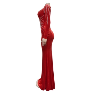 Détail d'une robe de soirée rouge longue et moulante avec strass et manches longues