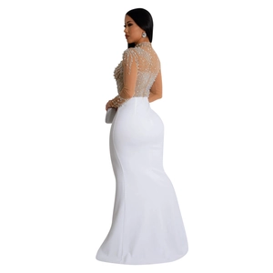 Close-up of elegant mesh top with intricate pearls and rhinestones on high-slit white dress