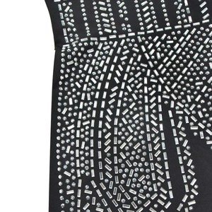 Close-up detail of silver rhinestones and geometric patterns on black long sleeve jumpsuit