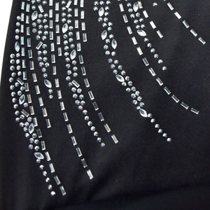 Detail of black mesh fabric with silver rhinestones in sparkling streamline patterns