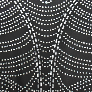 Macro detail of black mesh dress featuring shimmering rhinestones and silver sequins