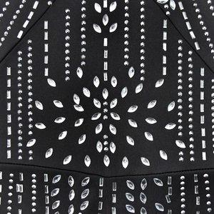 Détail de strass en étoile sur une combinaison noire avec des lignes géométriques