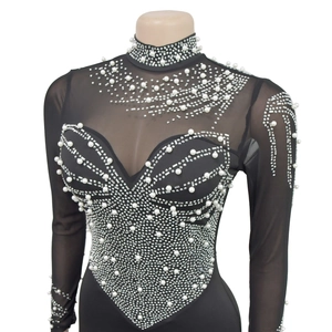 Close-up of black mesh top featuring elegant white pearls and rhinestone embellishments