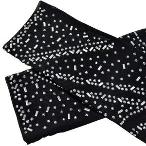 Detail shot of black mesh sleeves featuring sparkling silver rhinestones in a wave pattern