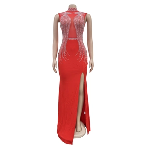 Detail of red slim fit evening gown featuring rhinestone embellishments and high slit