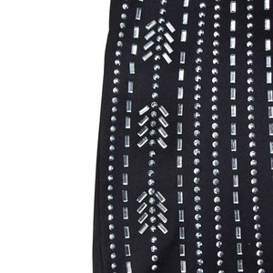 Vue détaillée des motifs géométriques en strass brillants sur le combipantalon noir