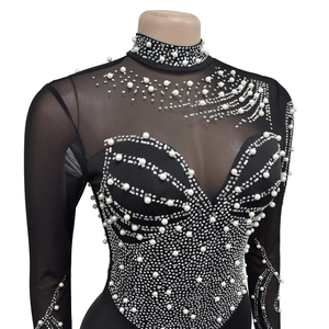 Detail of high collar black mesh jumpsuit with elegant pearl and rhinestone wave patterns