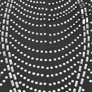 Detailed macro view of sparkling silver rhinestones on black mesh dress fabric