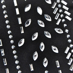Détail de strass argentés aux formes géométriques sur tissu de combinaison noire