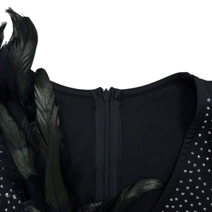 Detail of black dress featuring feather trim on shoulder and sparkling silver rhinestones