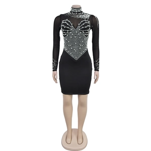 Close-up of black mesh mini dress featuring intricate pearl and rhinestone embellishments