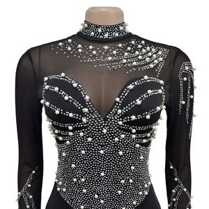 Detail of sheer mesh jumpsuit with silver rhinestones and white pearls on the neckline