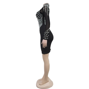 Detail of the side view showing white faux pearl and sequin embellishments on a black dress