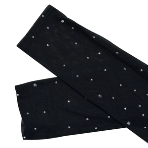 Close-up of black sheer mesh sleeves with sparkling rhinestones on a white background