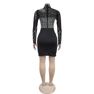 Back view of black bodycon dress featuring mesh sleeves with pearls and rhinestones