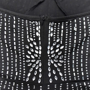 Détails macro des motifs en strass symétriques et fermeture éclair sur combishort noir