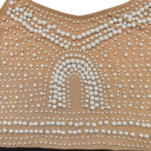 Dettaglio del tessuto in rete elegante con perle bianche e ricami di lusso