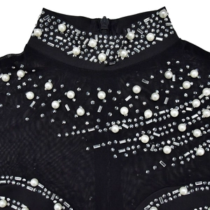 Macro detail of high collar with rhinestones and pearls on black mesh jumpsuit