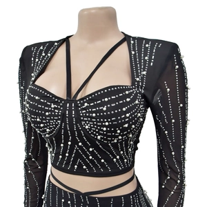 Detail du haut court avec manches en maille, strass et perles sur tissu noir