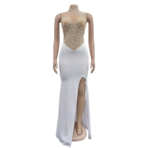 Detail of white evening dress with rhinestones, pearls and high-slit mesh design