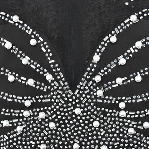 Close-up of black mesh dress with elegant pearl and rhinestone butterfly embellishments