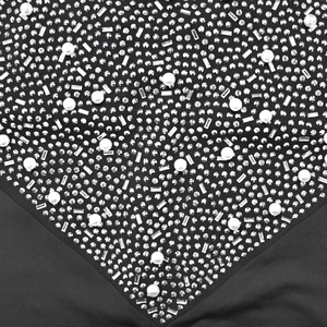 Detail of elegant black mesh dress featuring shimmering rhinestones and faux pearl patterns